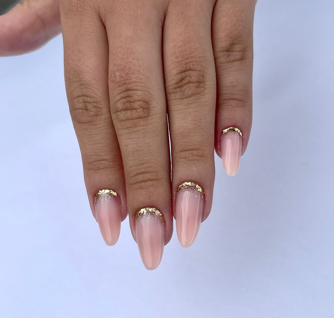 Manicure em tom nude com detalhe em folha dourada feita no Studio Lu Proença